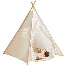 a teepee tent with two stuffed animals in it's bed and the inside is white