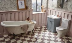 a bath room with a toilet a sink and a bath tub next to a window