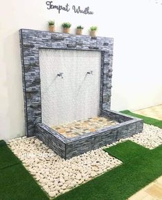 an outdoor fountain made out of stones and grass