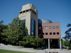 a building with trees and benches in front of it