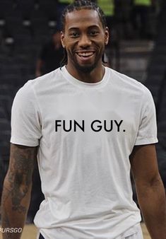 a man smiling while wearing a white shirt with the word fun guy written on it