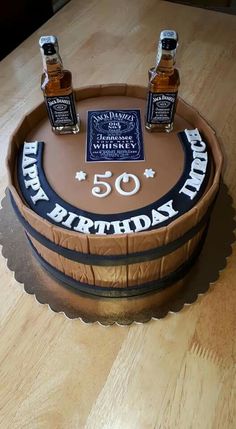 a birthday cake with three bottles of whiskey on top and the number fifty six in front