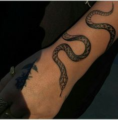 a person's arm with a snake tattoo on it