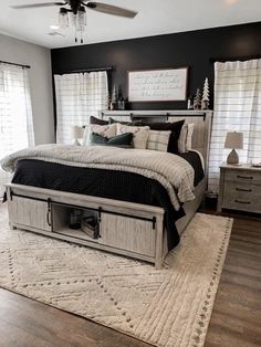 a bedroom with a bed, dresser and ceiling fan in the middle of the room