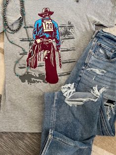 This t-shirt is adorable! "  It has a rodeo cowboy on the front. It will be your new favorite t-shirt!! Cowgirl Lifestyle, Swimsuit Jewelry, Bull Rider, Bull Riders, Rodeo Cowboy, Cowgirl Shirts, Curvy Jeans, Curvy Dress, Hand Drawn Design