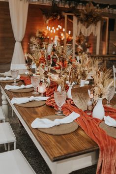 the table is set with place settings, napkins and vases filled with flowers