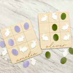 two wooden game pieces with different shapes and words on them sitting on a marble surface