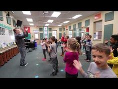 a group of young children dancing in a classroom