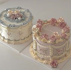 two cakes decorated with flowers and pearls on top of each other, one is pink