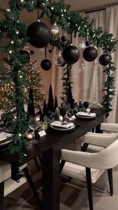 a dining room table decorated for christmas with black and white decorations