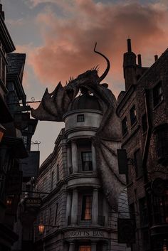 an image of a dragon statue on the side of a building at sunset or dawn