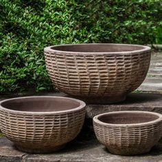 three brown bowls sitting on top of a stone slab