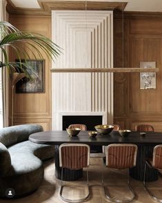 a dining room table with chairs around it and a fire place in the corner behind it