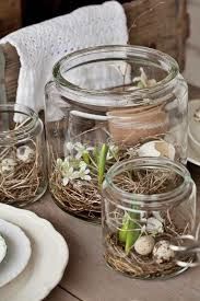 some glass jars filled with plants and eggs