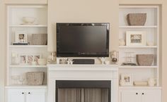 a flat screen tv mounted on top of a white fireplace