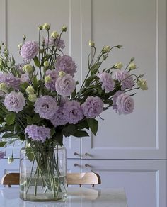 a vase filled with purple flowers sitting on top of a table