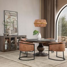 a dining room table with two chairs and a vase on the table in front of an arched window