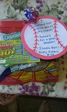 a child's hand holding up a baseball themed gift bag with candy and candies