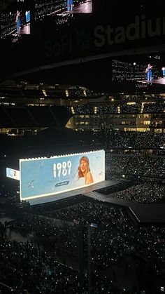 a large screen in the middle of a stadium filled with people