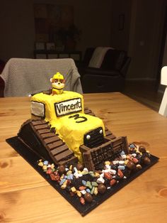 a cake made to look like a construction vehicle on top of a table with candy