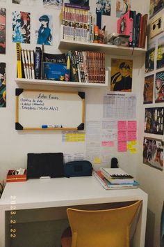 a white desk topped with a laptop computer next to a book shelf filled with books