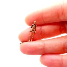 a tiny skeleton is sitting in someone's hand with it's fingers out