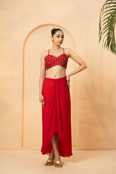 Featuring a red co-ord set which contains a blouse, cape and a dhoti skirt. The blouse and cape is fully hand-embroidered with pearl beads, cutdana,, anchor thread and sequin work Embroidered Draped Blouse Piece For Party, Red Embellished Pre-draped Saree For Party, Red Draped Designer Choli, Embroidered Draped Lehenga For Diwali, Embroidered Draped Sets For Diwali, Embellished Red Palazzo Set For Party, Diwali Embroidered Draped Lehenga, Draped Embroidered Party Set, Festive Draped Embroidered Choli