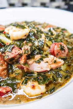 a white plate topped with shrimp and greens