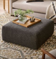 a living room with a couch, chair and coffee table on top of a rug