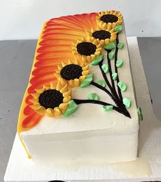 a cake decorated with sunflowers on top of a table