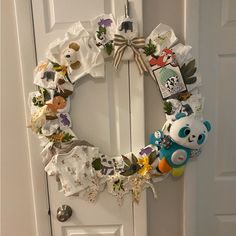 a white door with a wreath made out of baby's clothes and teddy bears