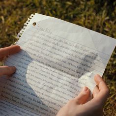 someone is holding a piece of paper with writing on it in their hands, while another person holds the paper