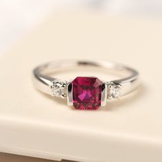 All HANDMADE ITEMS SHIP IN APPROX 8 DAYS Main Stone: Lab created ruby Main Stone Size: Asscher cut 6 mm x 6 mm Main Stone Weight: 1.44 carat Side Stone: Round shaped CZ Height From The Ring Setting Bottom(to gemstone top): about 5.17 mm Width of Ring band Measure: gradually varied,about 2.07-2.79 mm Material: 925 Sterling Silver/14K White Gold/14K Yellow Gold/14k Rose Gold Engraved: Available For FreeNo more than 13 letters) Customized:Of course! Tell me what you want Includes With Order: All of Ruby Silver Rings For Women, Emerald Cut Ruby Ring With Birthstone, White Gold Ruby Ring With Lab-created Gemstone, Classic Promise Jewelry With Lab-created Ruby, Classic Lab-created Ruby Jewelry For Promise, Asscher Cut Ruby Ring With Prong Setting For Anniversary, Asscher Cut Ruby Jewelry With Center Stone, Emerald Cut Solitaire Ruby Ring, Classic Asscher Cut Ruby Ring For Anniversary