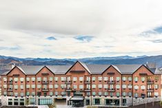 a large building with lots of windows in front of mountains