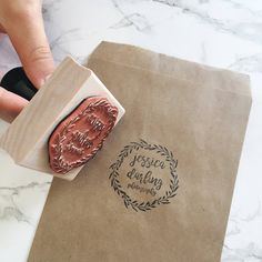 a stamper is being used to make a logo on a paper bag