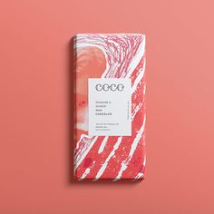 a pink and white chocolate bar on a pink surface with the words coco written in black