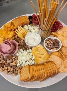 a white plate topped with lots of different types of snacks and dips on top of it