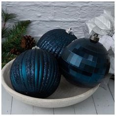 two shiny blue christmas ornaments in a bowl