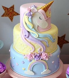 there is a cake with a unicorn on it and cupcakes next to it