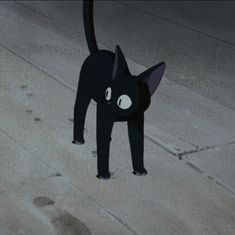 a black cat standing on top of a sidewalk