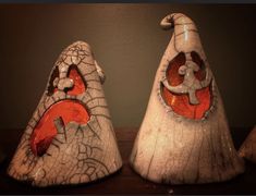 two white and orange vases sitting on top of a wooden table next to each other