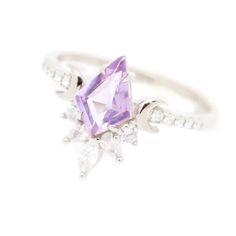 A gem of lavender Quartz shines in a sky of diamonds. Befitting a galactic princess, the Veronica Ring features a mesmerizing Lavender Quartz center stone framed with lunar accents and an arrangement of shimmering white cubic zirconia accent stones. Another series of accent stones line the ring on each side, adding ext Lavender Amethyst Cubic Zirconia Ring, Lavender Amethyst Ring In Cubic Zirconia, Lavender Fine Jewelry With Diamond Accents, Wedding Amethyst Diamond Ring With Accents, Lavender Amethyst Jewelry With Diamond Accents, Wedding Amethyst Diamond Ring With Diamond Accents, Luxury Lavender Wedding Jewelry, Luxury Lavender Jewelry For Wedding, Purple Marquise Diamond Jewelry