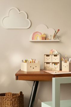 a desk with some boxes on it and a cloud shaped wall hanging above the desk