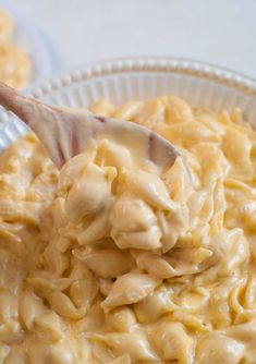 a spoon full of macaroni and cheese in a bowl