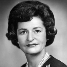 an old black and white photo of a woman wearing pearls