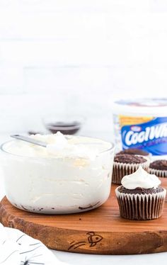 cupcakes with frosting on a cutting board next to a can of coconut milk