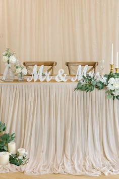 the table is set up with candles and flowers for mr and mrs signs on it