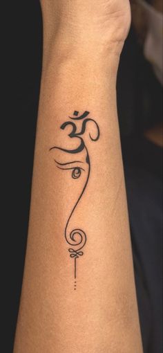 a woman's arm with a tattoo on it and an om symbol in the middle