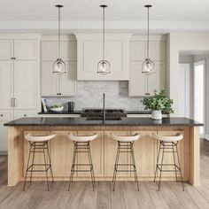 a kitchen island with four stools in front of it and three lights hanging from the ceiling