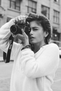 black and white photograph of woman holding up camera